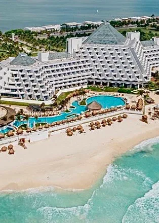 Paradisus Cancún seen from the air, its pyramid-shaped buildings above the beach and pools