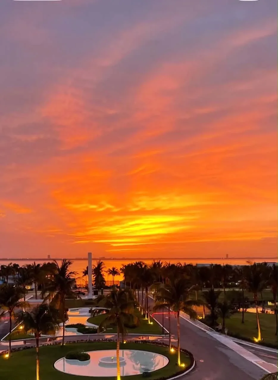 Sunset over the lagoon and palm-lined grounds at Paradisus Cancún